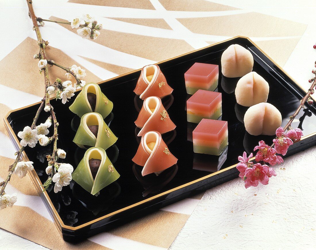 Japanese sweets on black platter; flowers