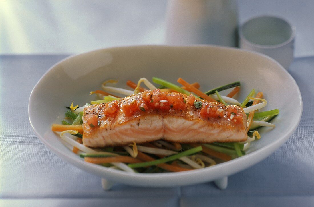 Salmon fillet with tomatoes on julienne vegetables