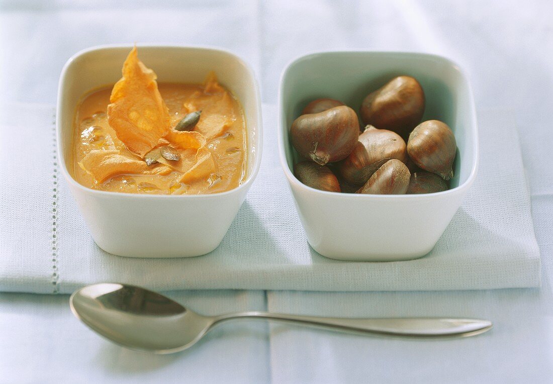 Pumpkin soup with pumpkin seeds and sweet chestnuts in bowls