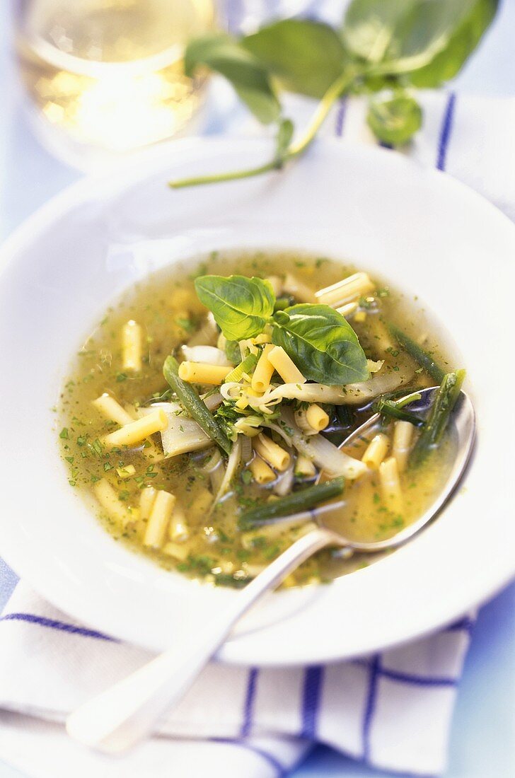 Green soup with noodles, vegetables and pesto