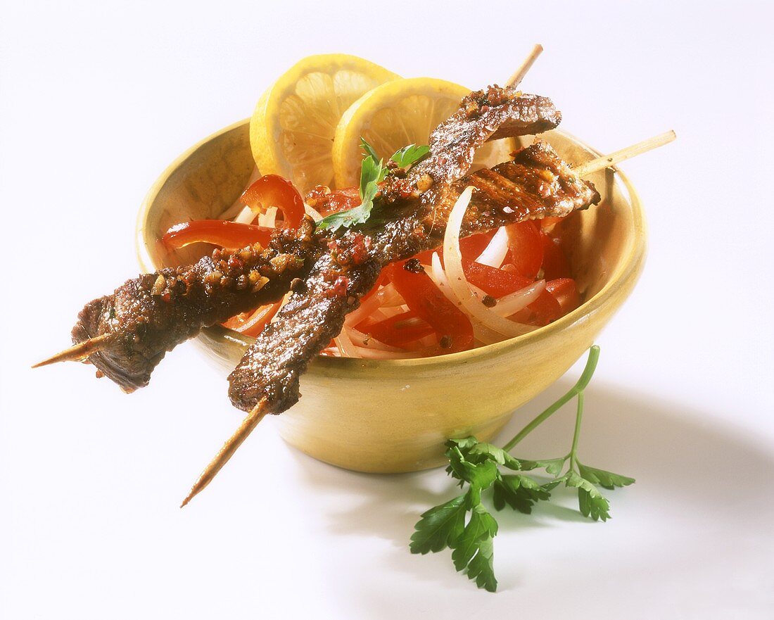 Middle Eastern lamb kebabs on onions and peppers