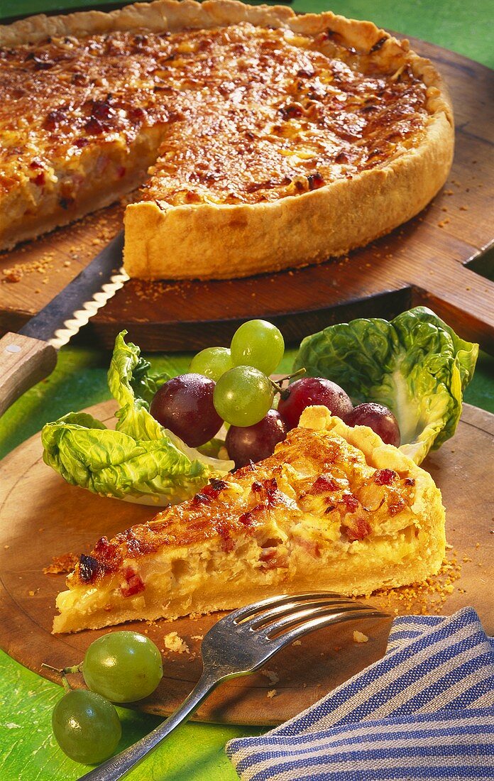 Quiche Lorraine with grapes on wooden plates