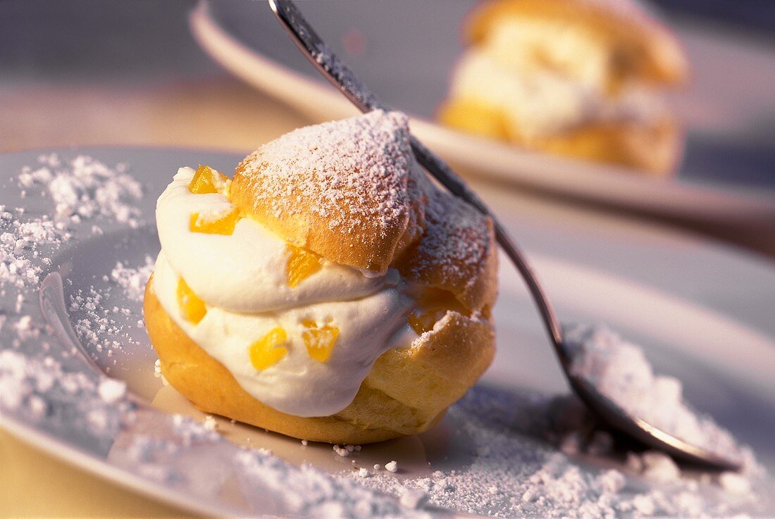 Cream puff with peaches, quark cream and icing sugar