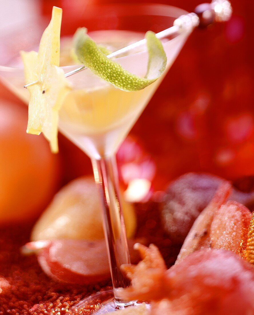 Champagner-Sangria im Glas, umgeben von kandierten Früchten