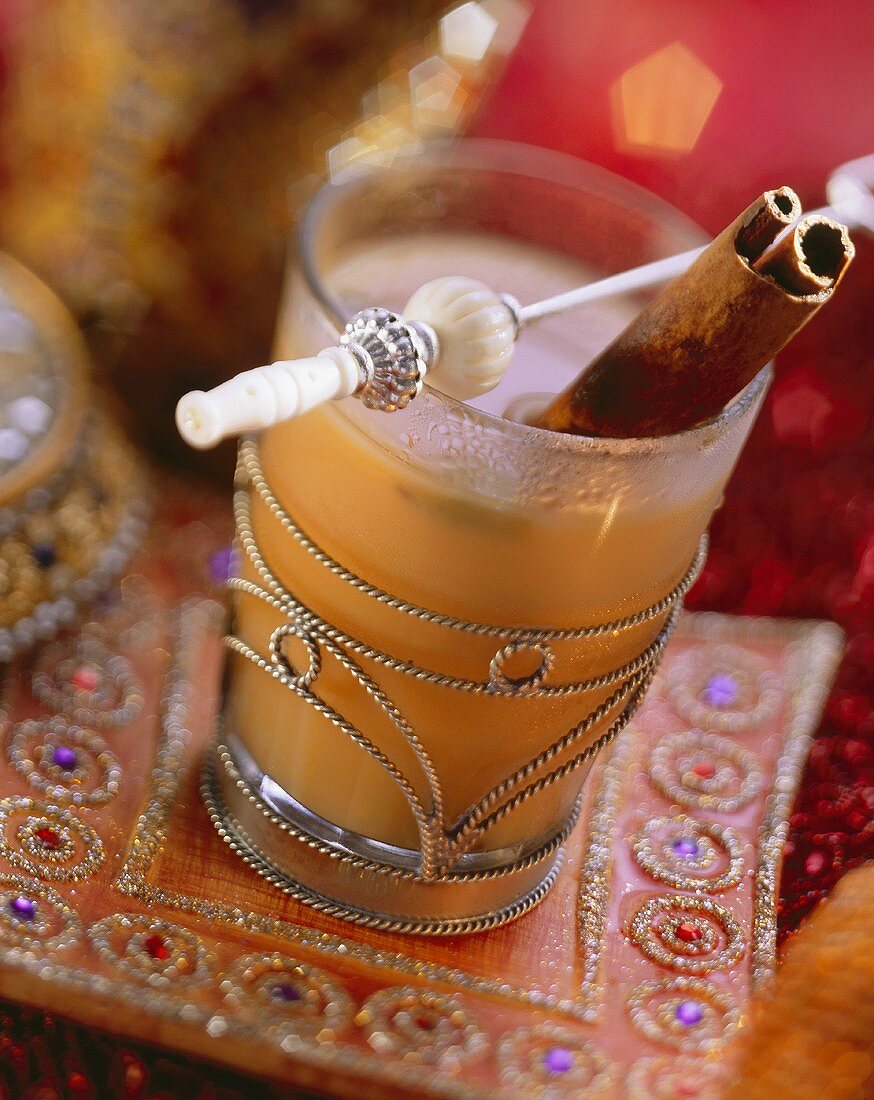 Indian spiced tea with cinnamon stick in glass