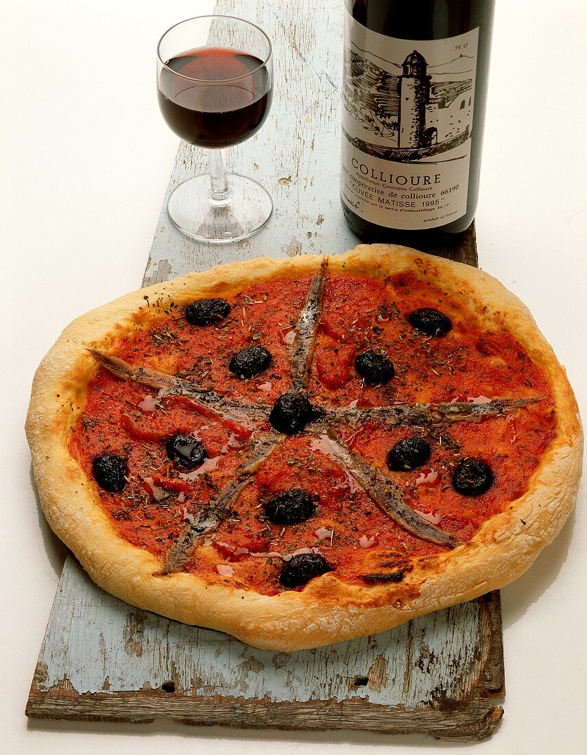 Pizza with anchovies and olives; red wine