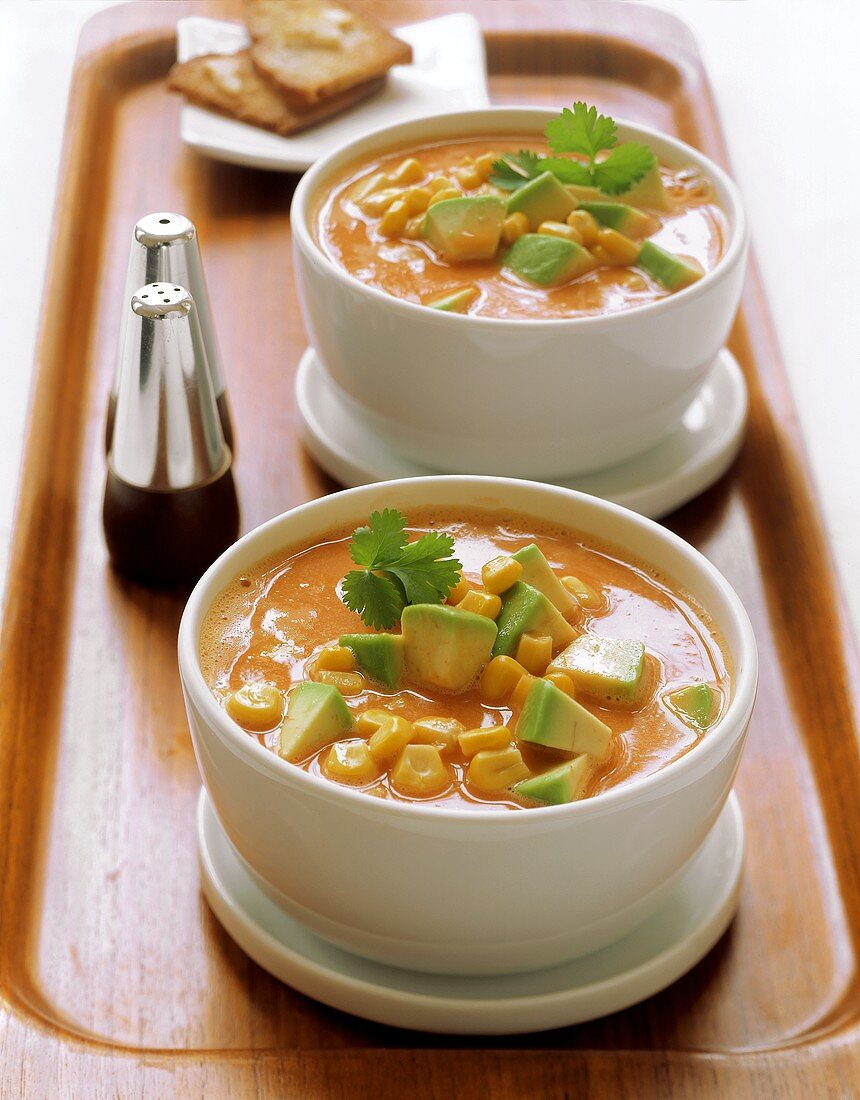 Sweetcorn and avocado soup in bowls on tray