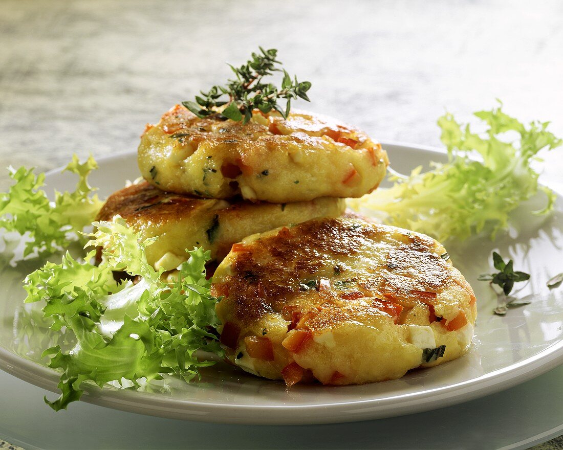 Kartoffelplätzchen mit Feta und Tomaten, garniert mit Salat