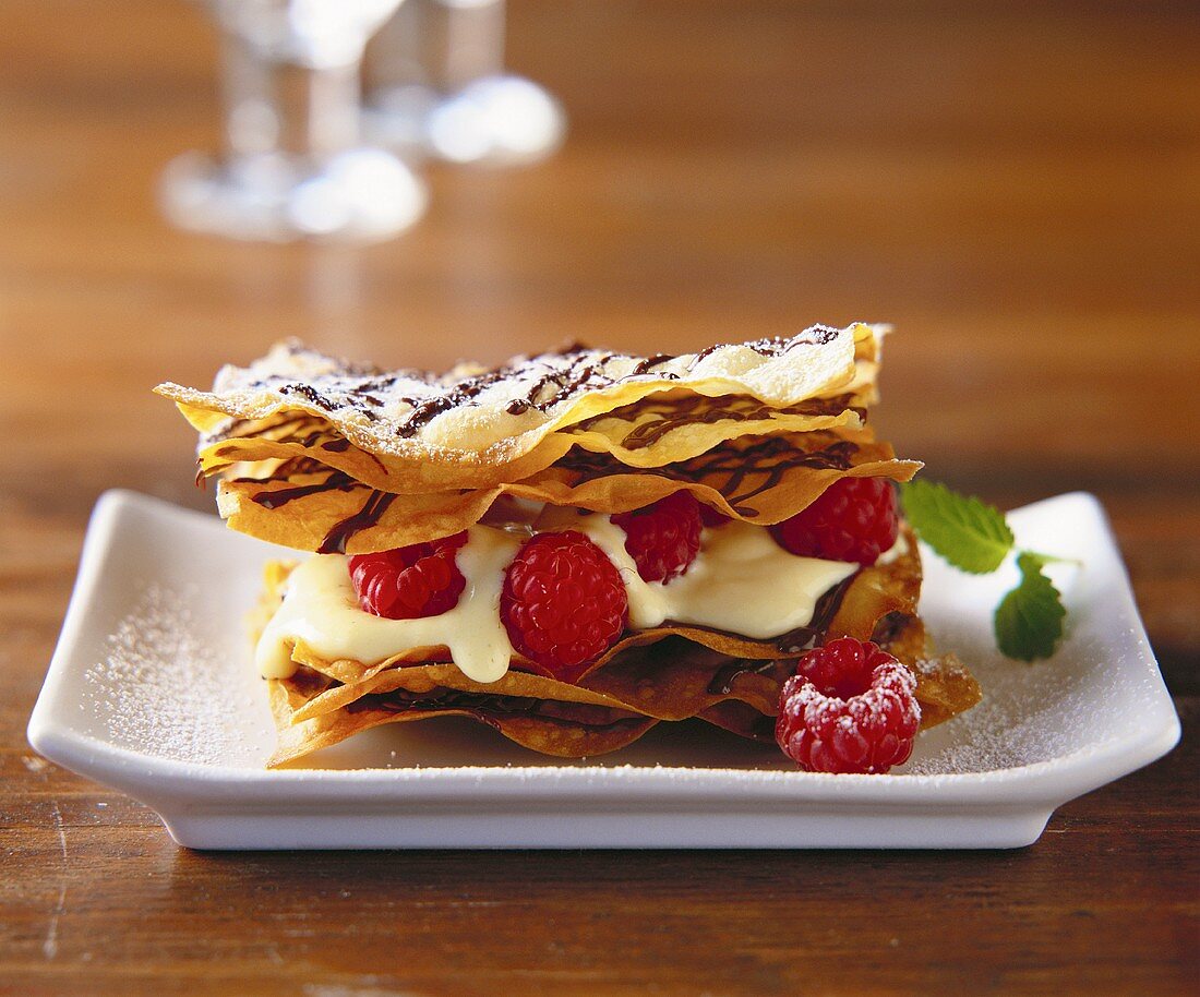 Filoteig mit Himbeeren und Creme auf braunem Tisch