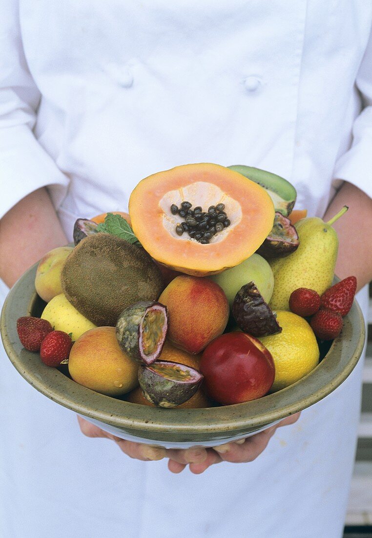 Chef holding bowl of exotic fruits