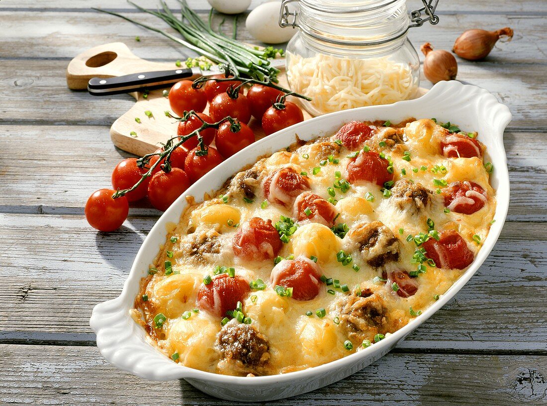Tomato and meat gratin with cheese and chives