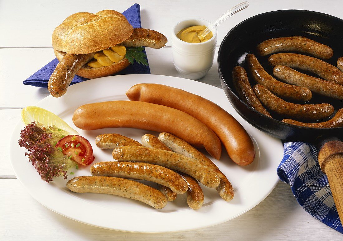Fried sausages & Vienna sausages on plate; roll with sausage