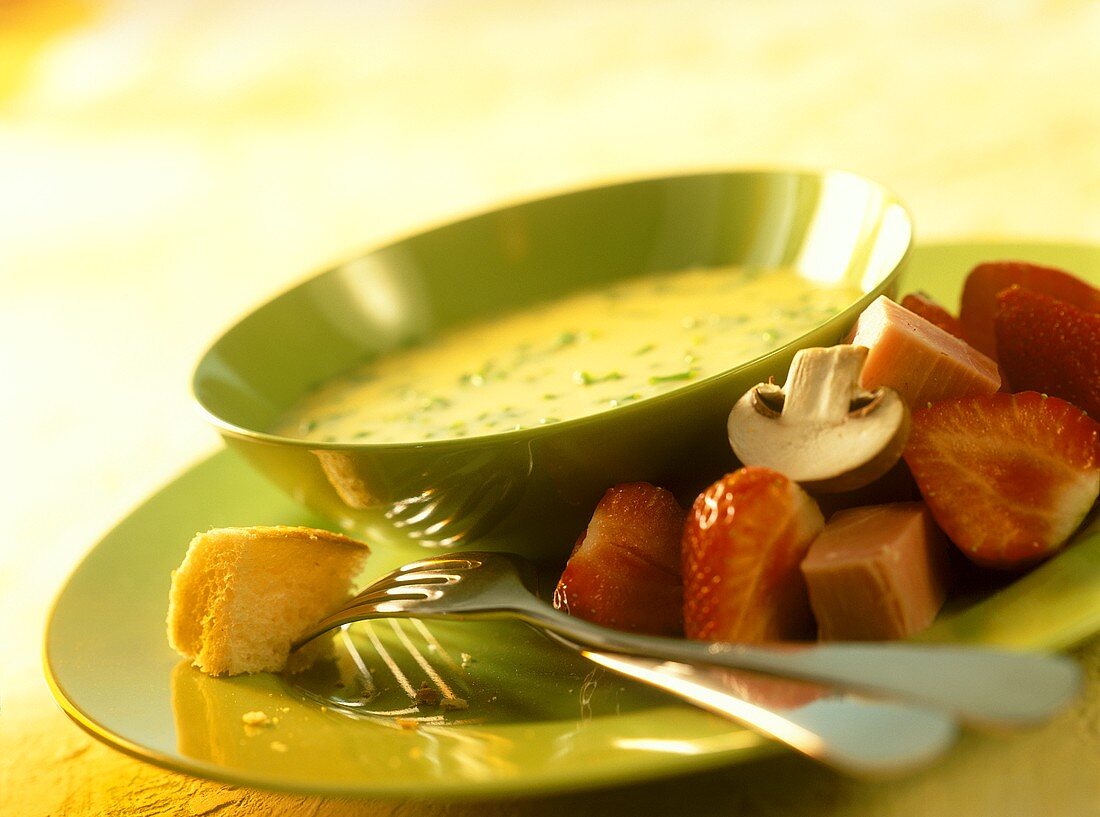 Käsefondue mit Schnittlauch, Schinken und Erdbeeren