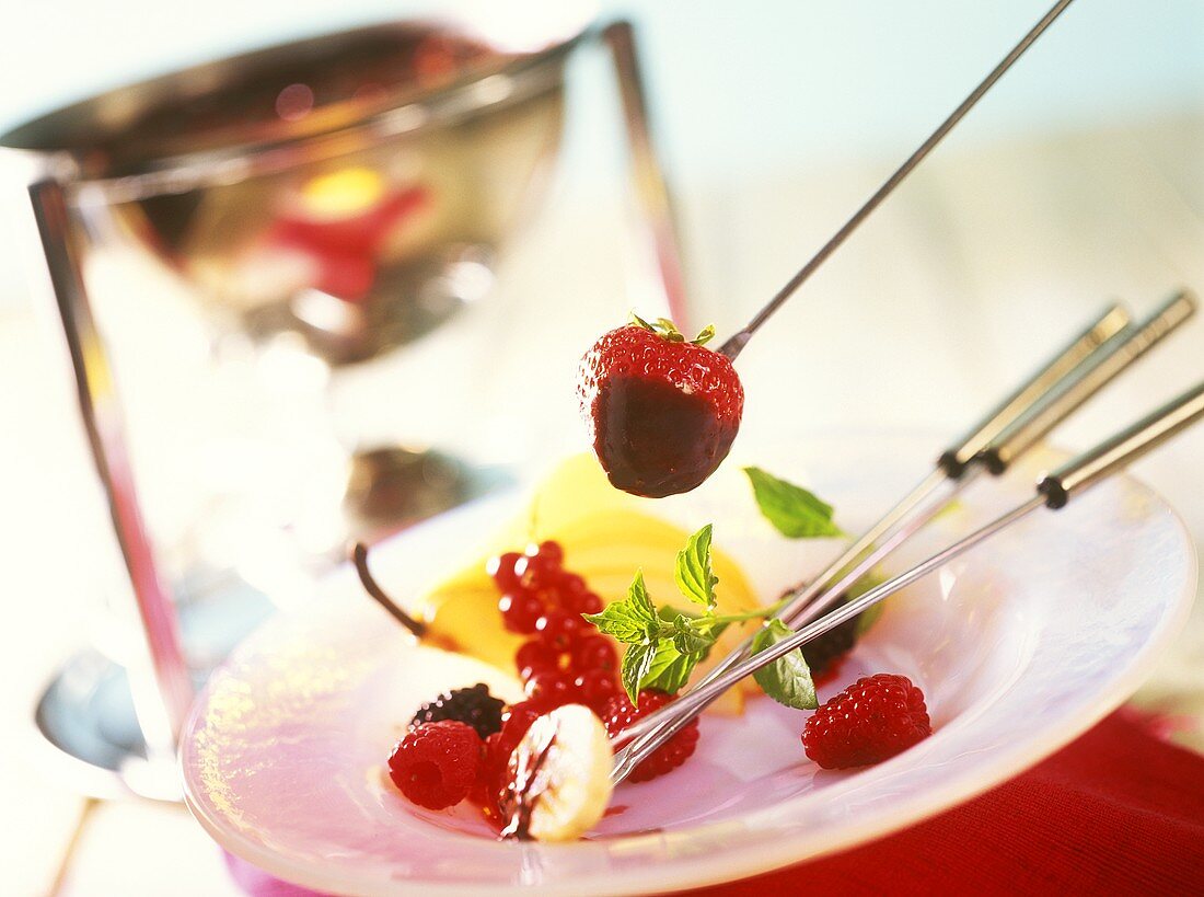 Chocolate fondue with fruit on fondue forks