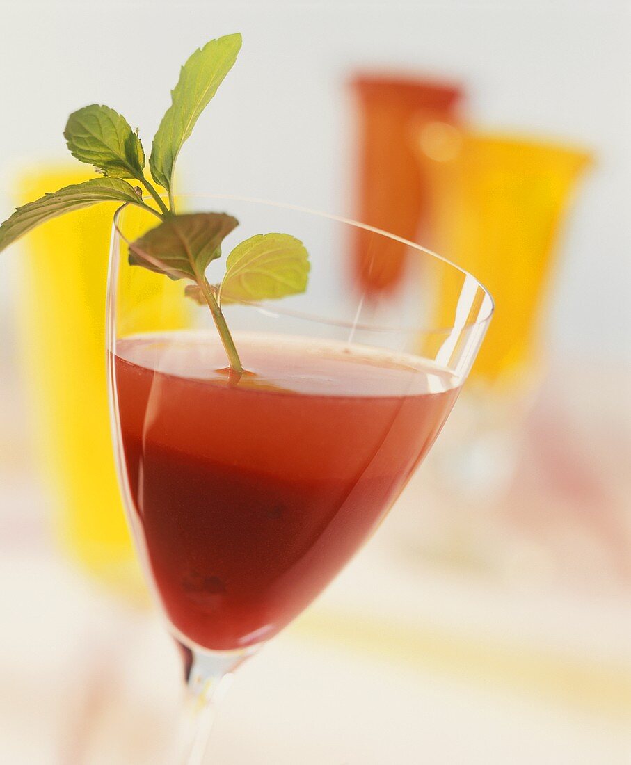 Cocktail mit Weißwein, Himbeermus und frischer Minze