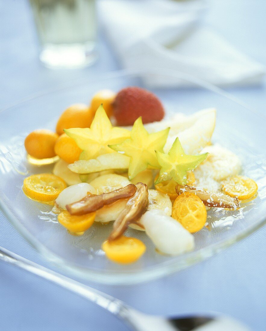 Exotic fruit salad with maple syrup and coconut flakes