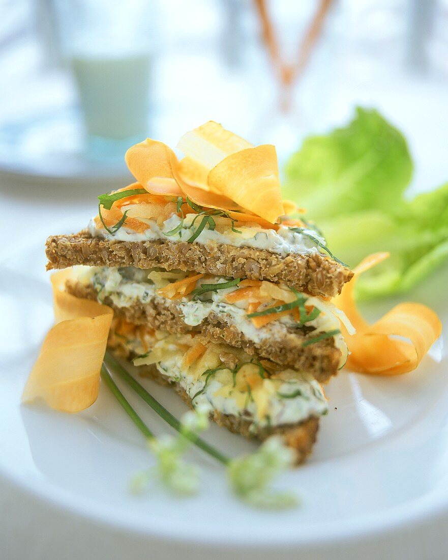 Wholemeal bread triangles with soft cheese, nuts and carrots