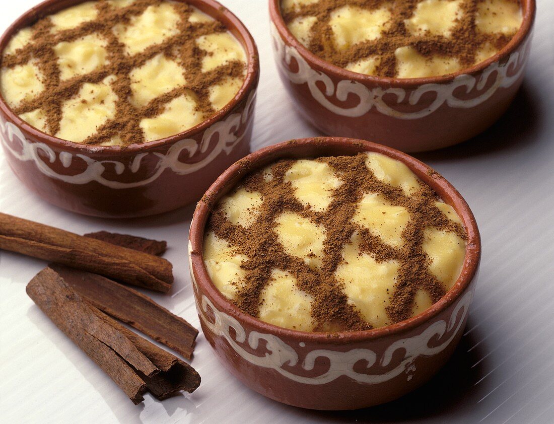 Portuguese rice dessert with cinnamon in terracotta bowls
