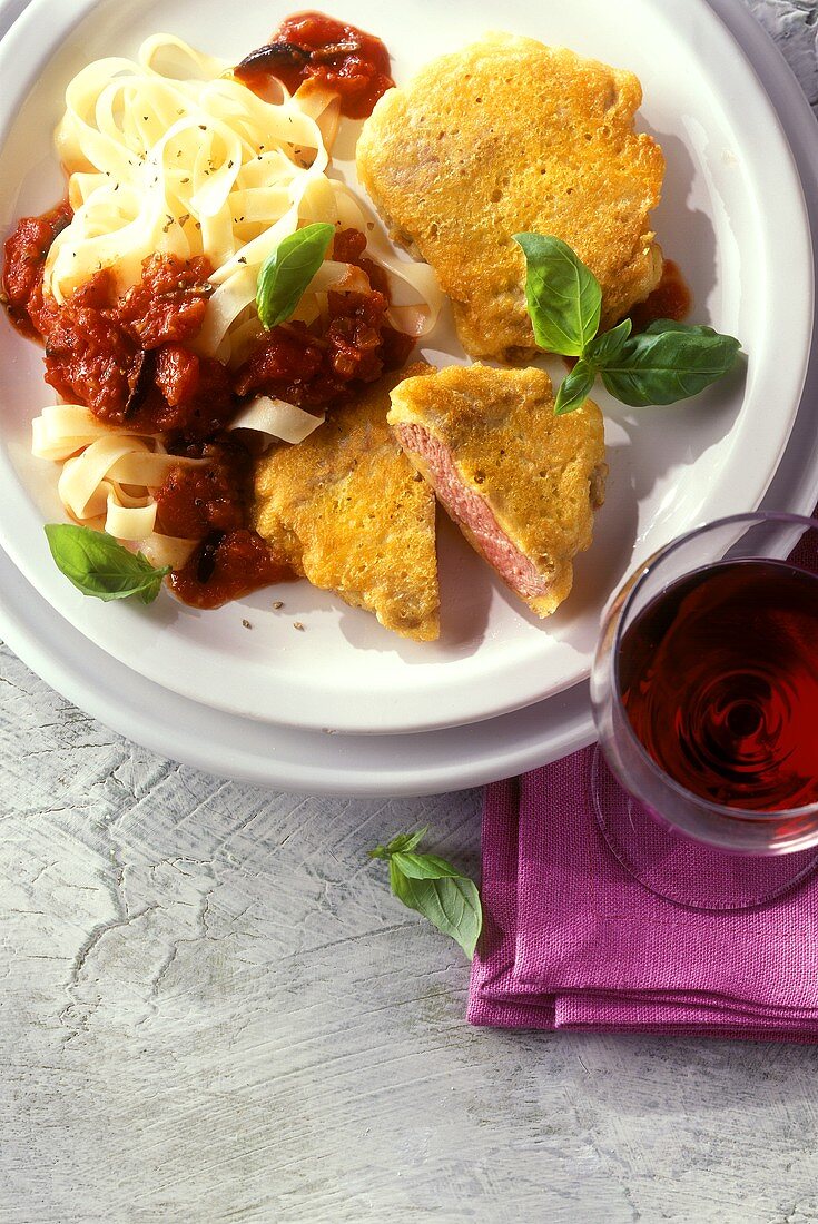 Piccata with ribbon pasta, tomato sauce and basil