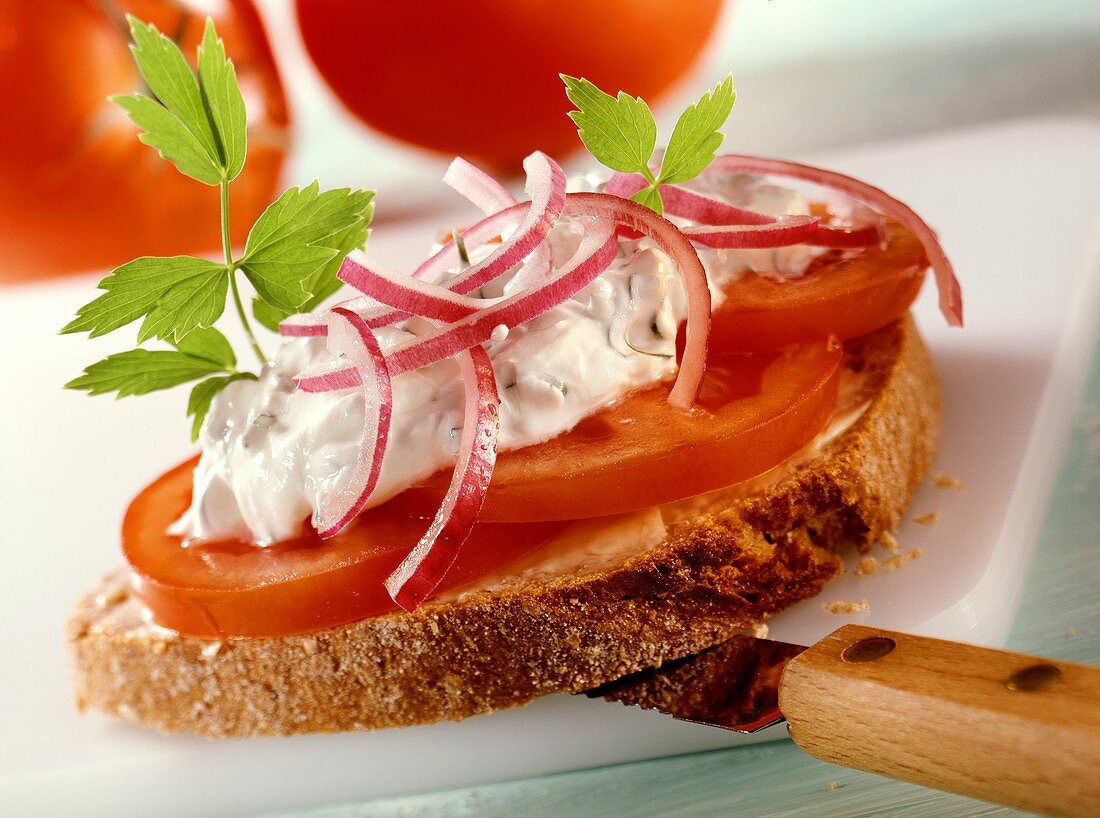 Belegtes Brot mit Tomaten und Sauerrahm-Liebstöckel-Creme