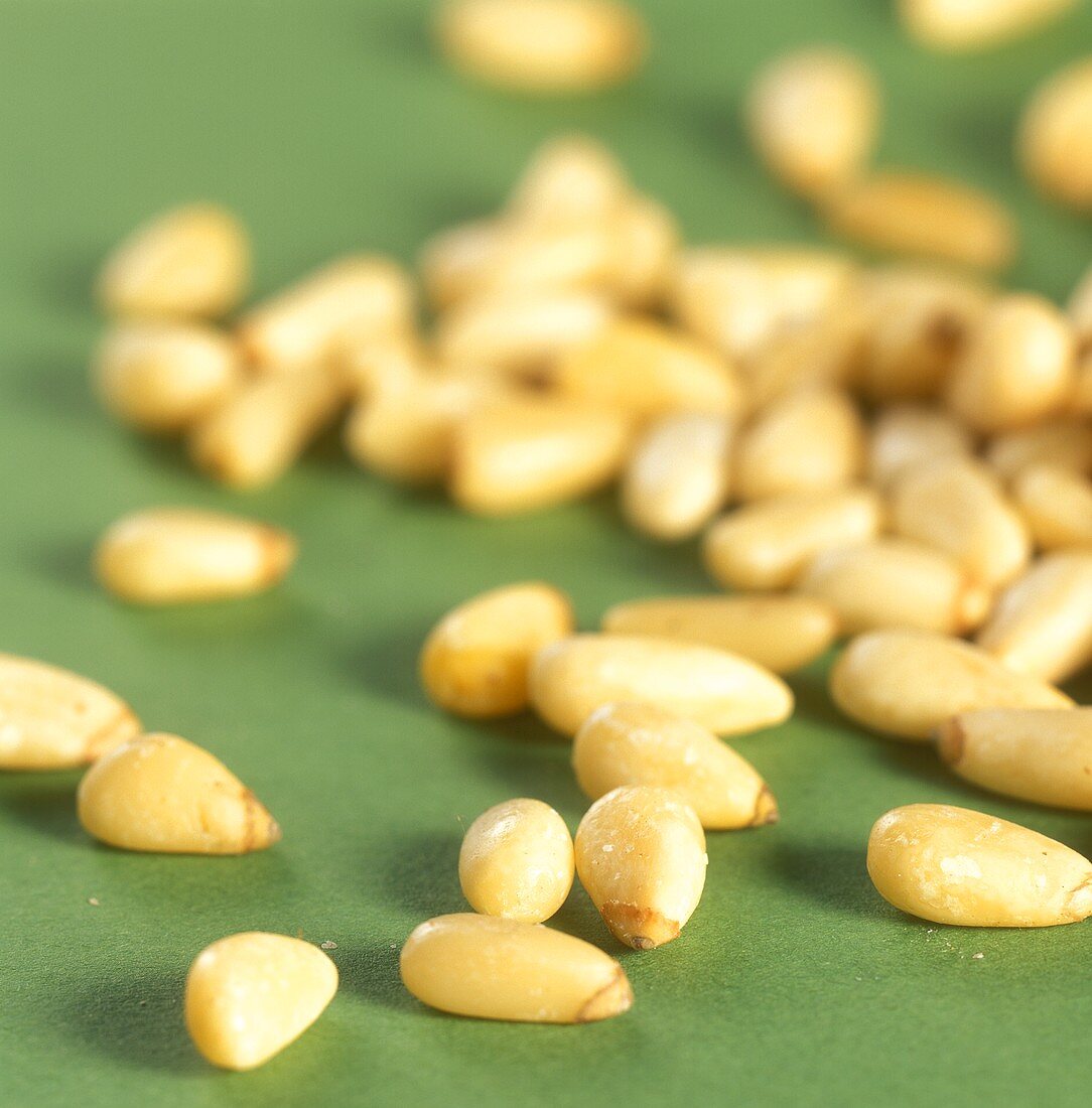 Pine nuts on green background