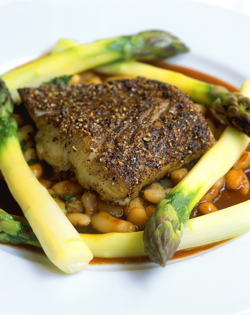 Fried sea bass on beans and green asparagus