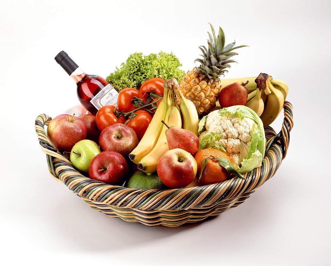 Früchtekorb mit Gemüse und Weinflasche