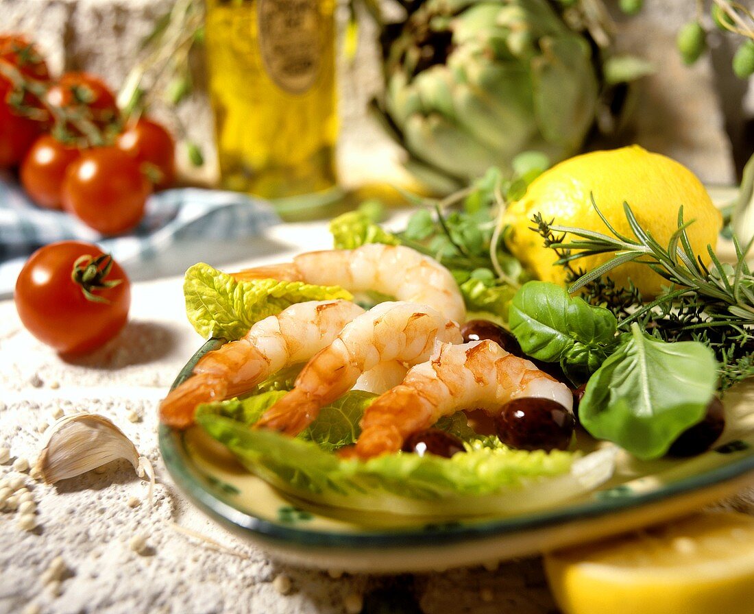 Shrimps with olives, herbs and lemon on bed of lettuce