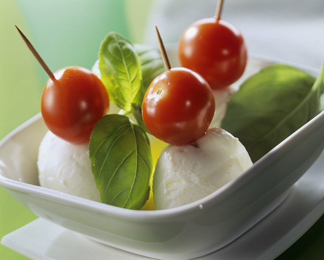 Tomato & mozzarella on cocktail sticks with fresh basil