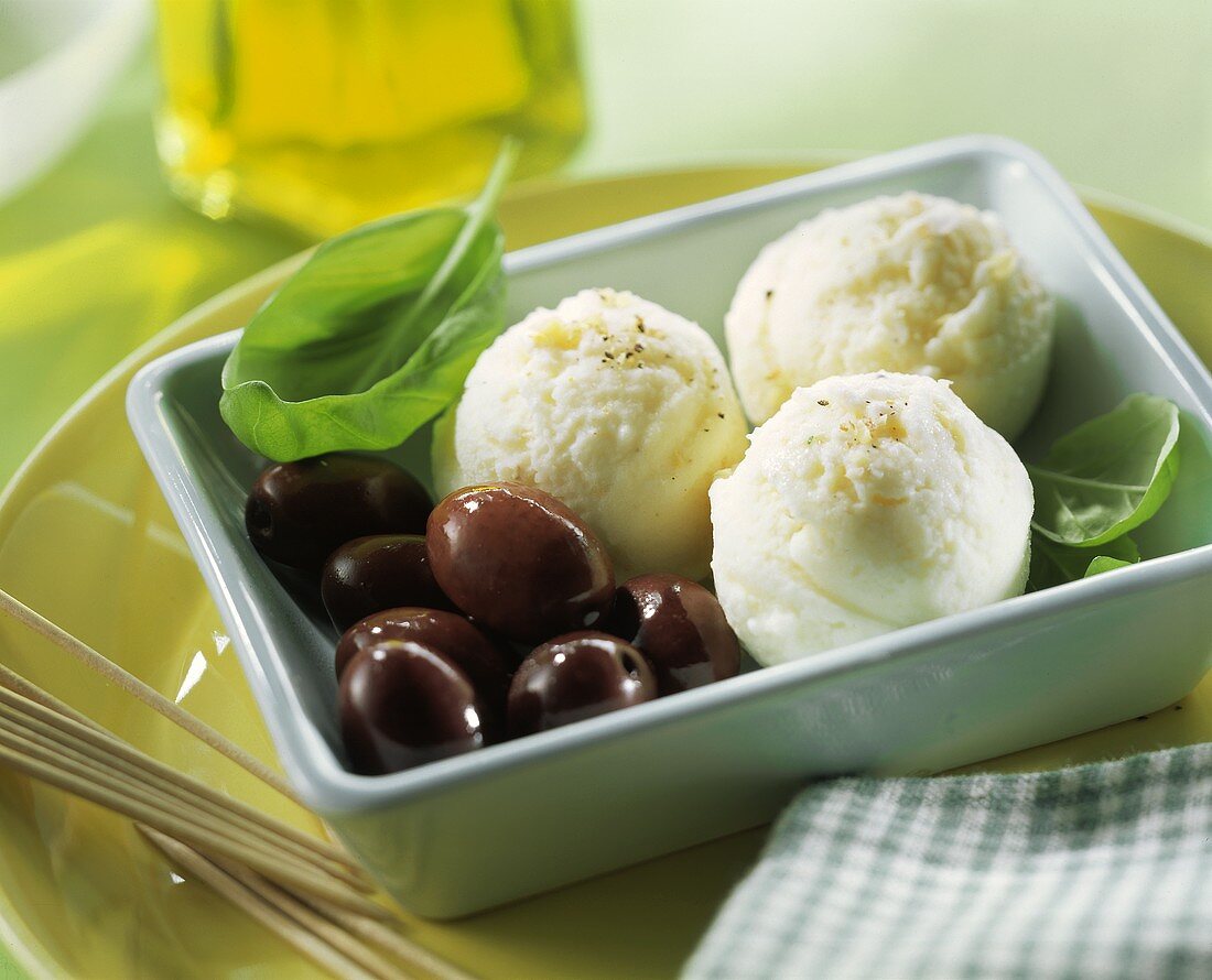 Cheese ice cream with black olives and basil