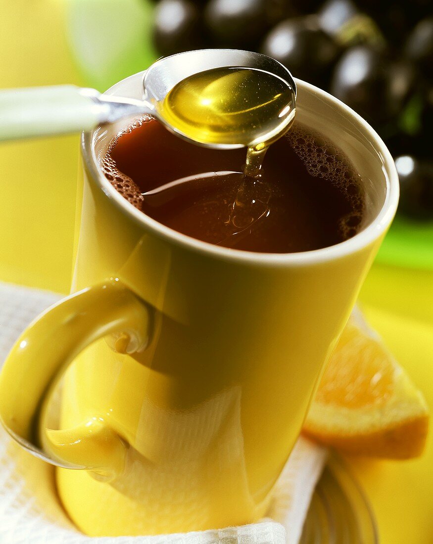 Traubenpunsch mit Honig in gelber Tasse