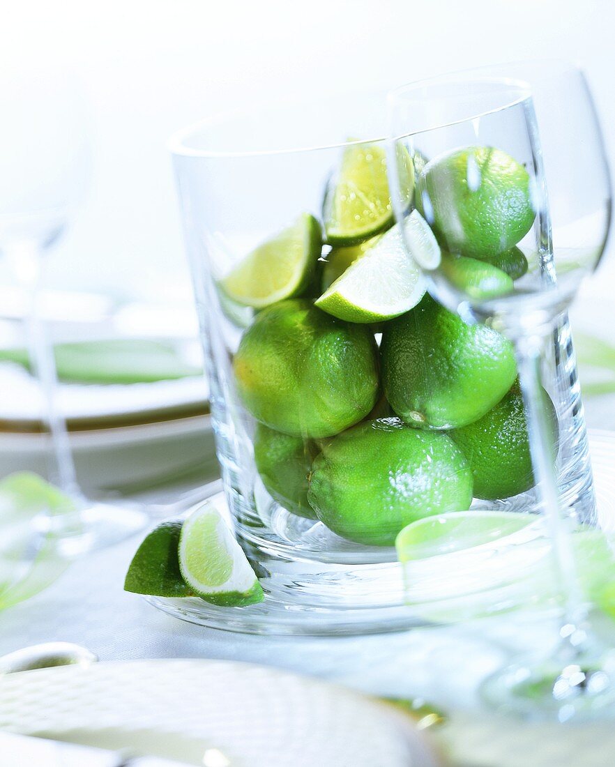 Limes in large glass container on laid table