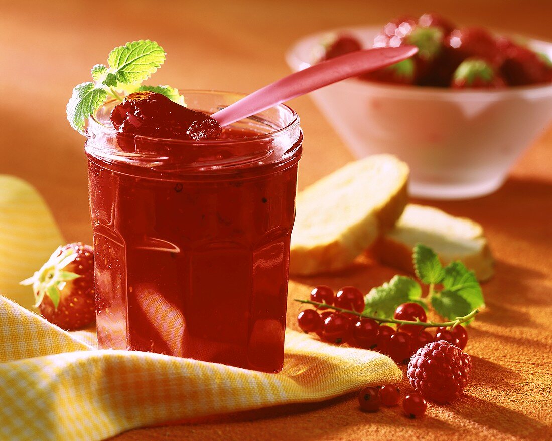 Berry jam in jar; white bread; fresh berries