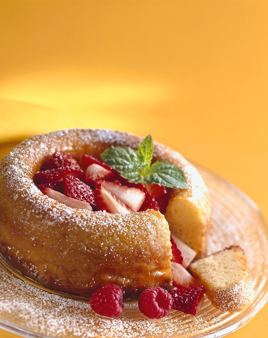 Savarin with strawberries and mint (a piece cut)