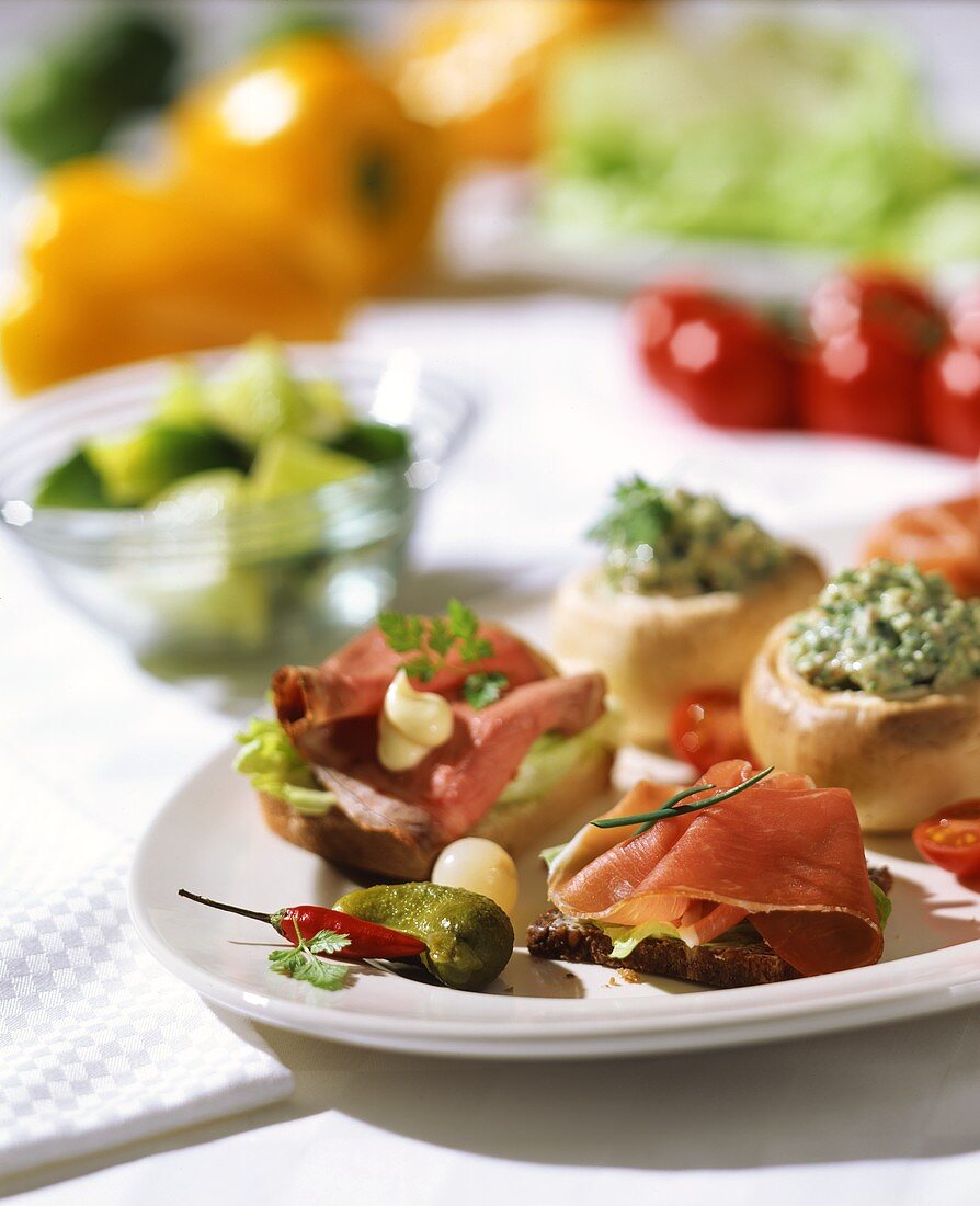 Open sandwiches and stuffed mushrooms; white tablecloth