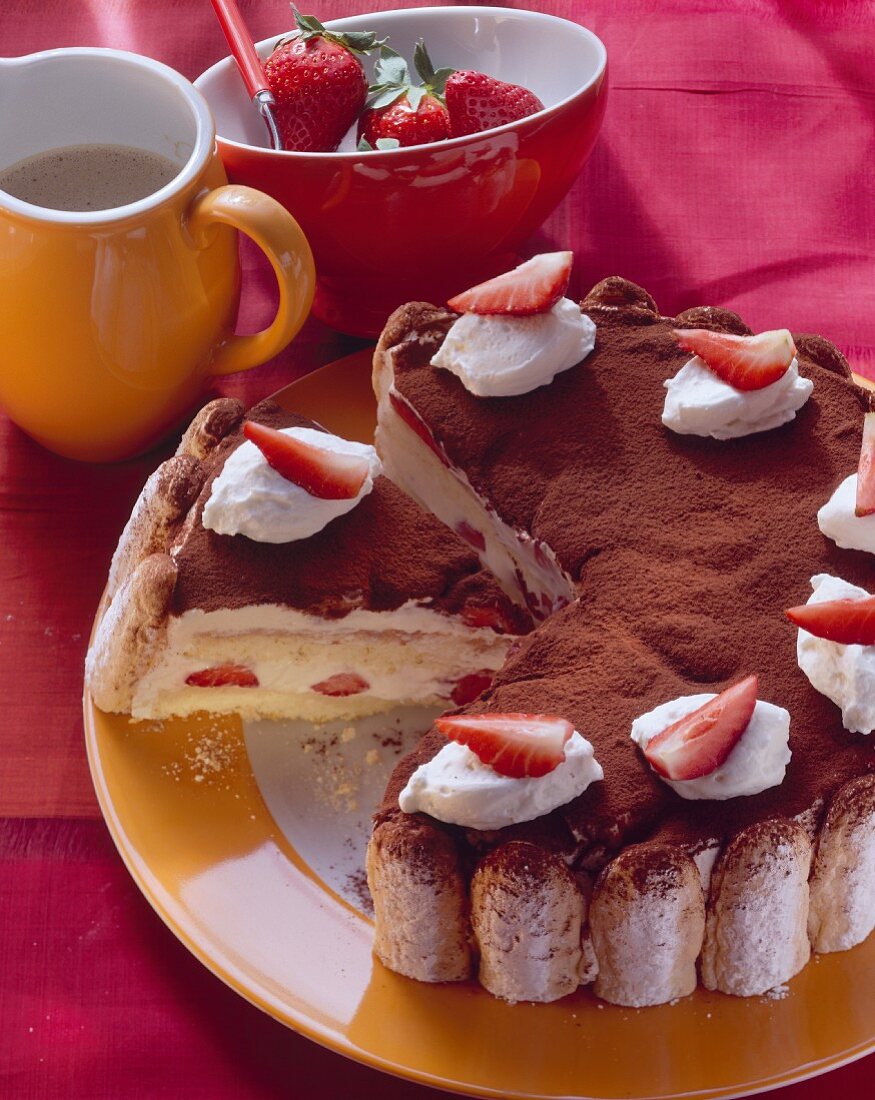 Tiramisu cake with strawberries and cream, a piece cut