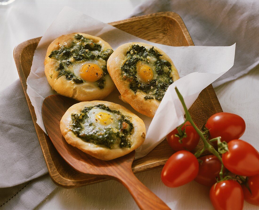 Kleine Spinatpizzen mit Ei; Strauchtomaten