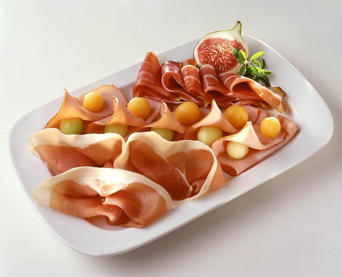 Three types of ham with melon balls and fig