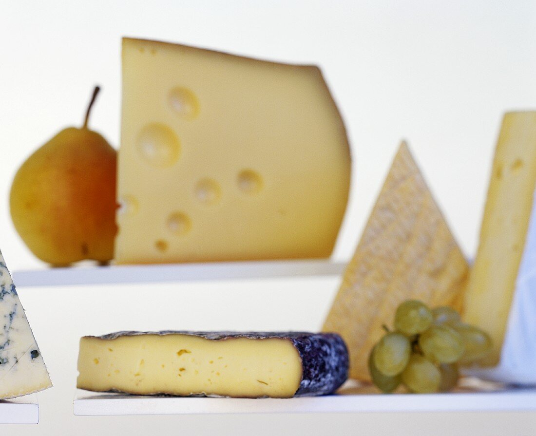 Various types of cheese with pear and grapes