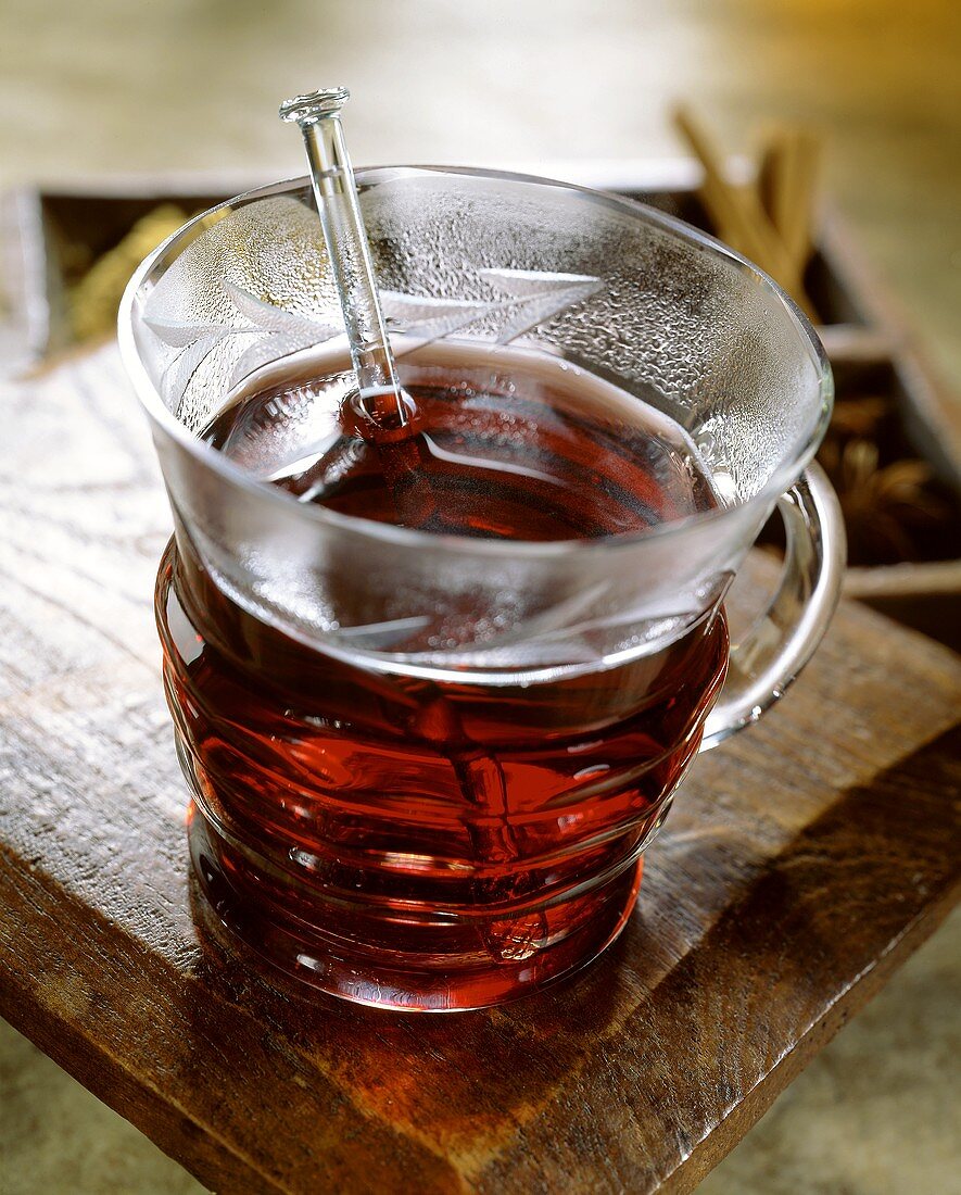 Rum-Gewürz-Punsch in Glastasse mit Glasstab