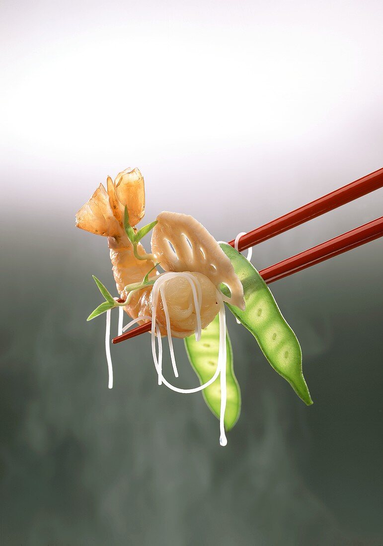 Shrimp, vegetables and noodles on chopsticks