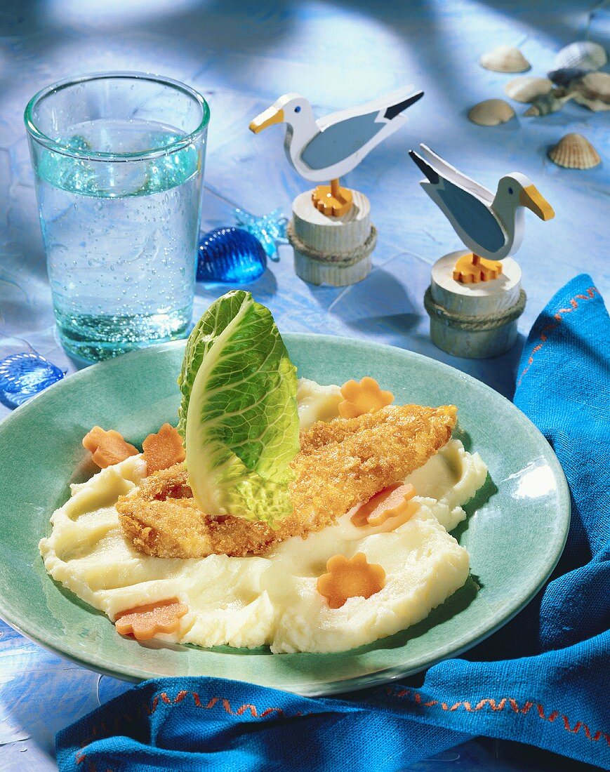 Breaded fish on mashed potato with carrot flowers