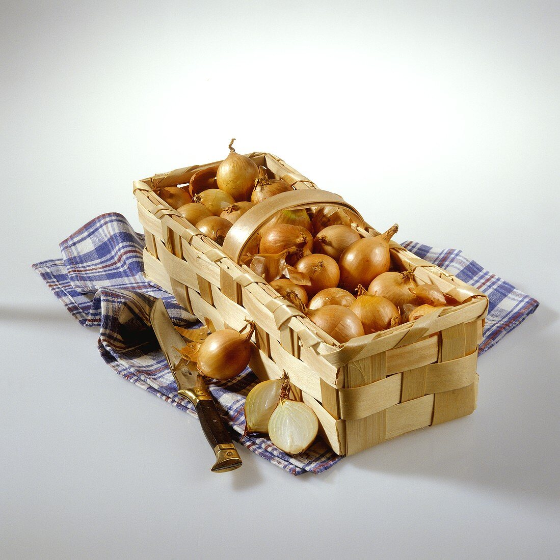 Onions in chip basket on blue checked cloth