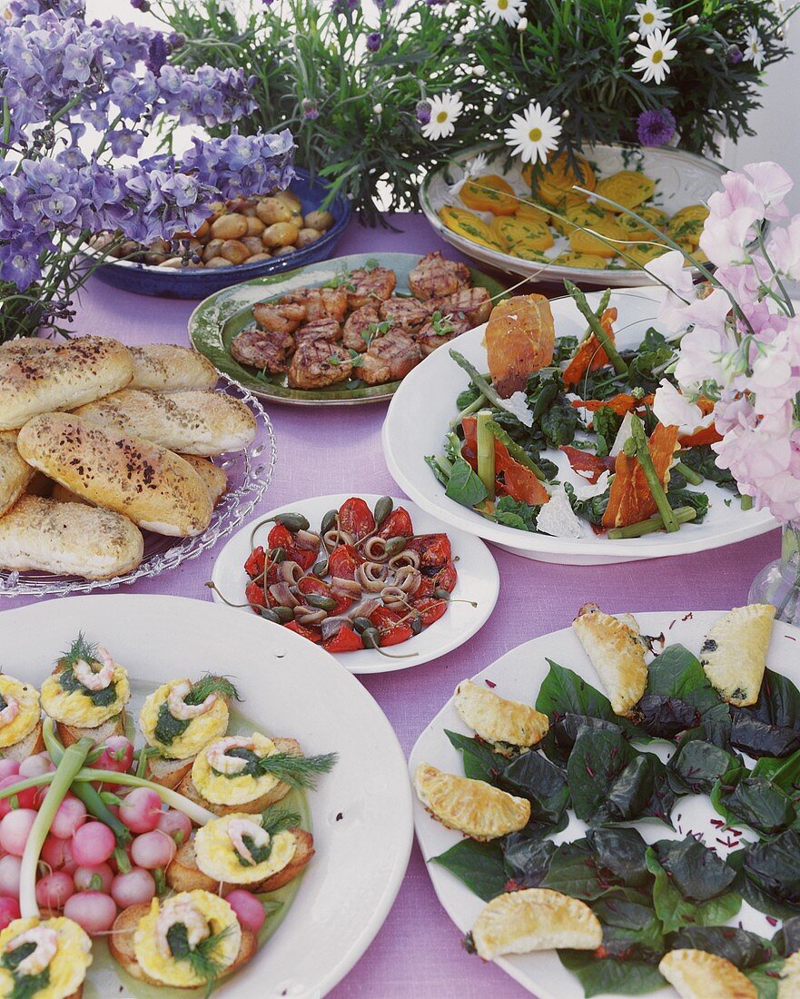 Schwedisches Sommerbuffet mit Salaten, Fleisch und Brötchen