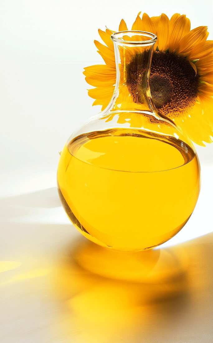 Sunflower oil in front of sunflower