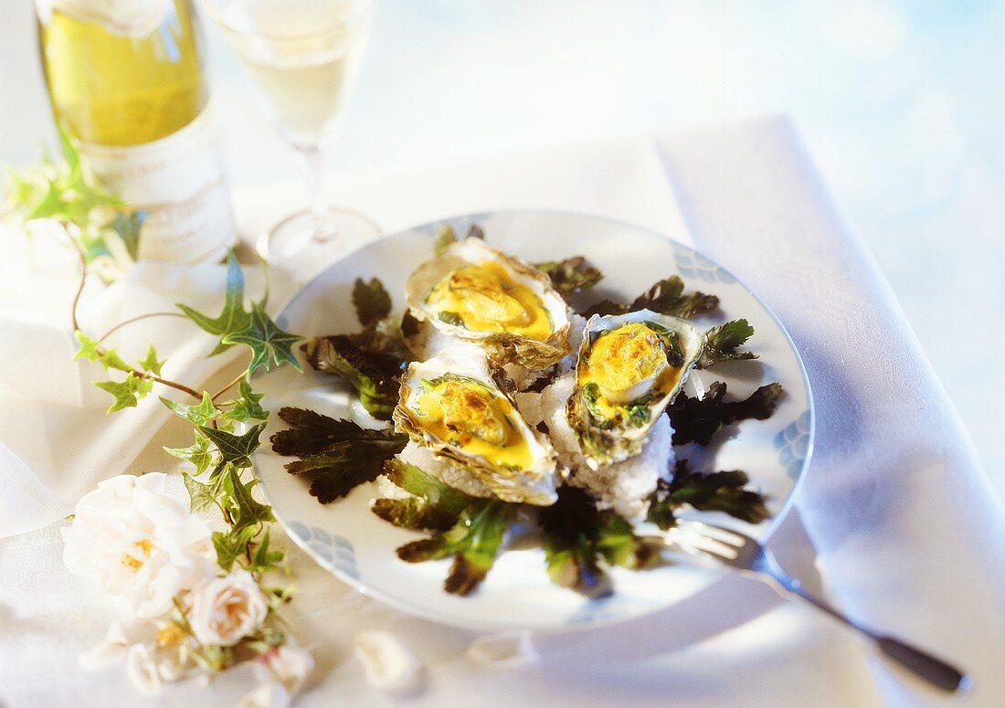 Überbackene Austern und Weißwein, stimmungsvoll arrangiert