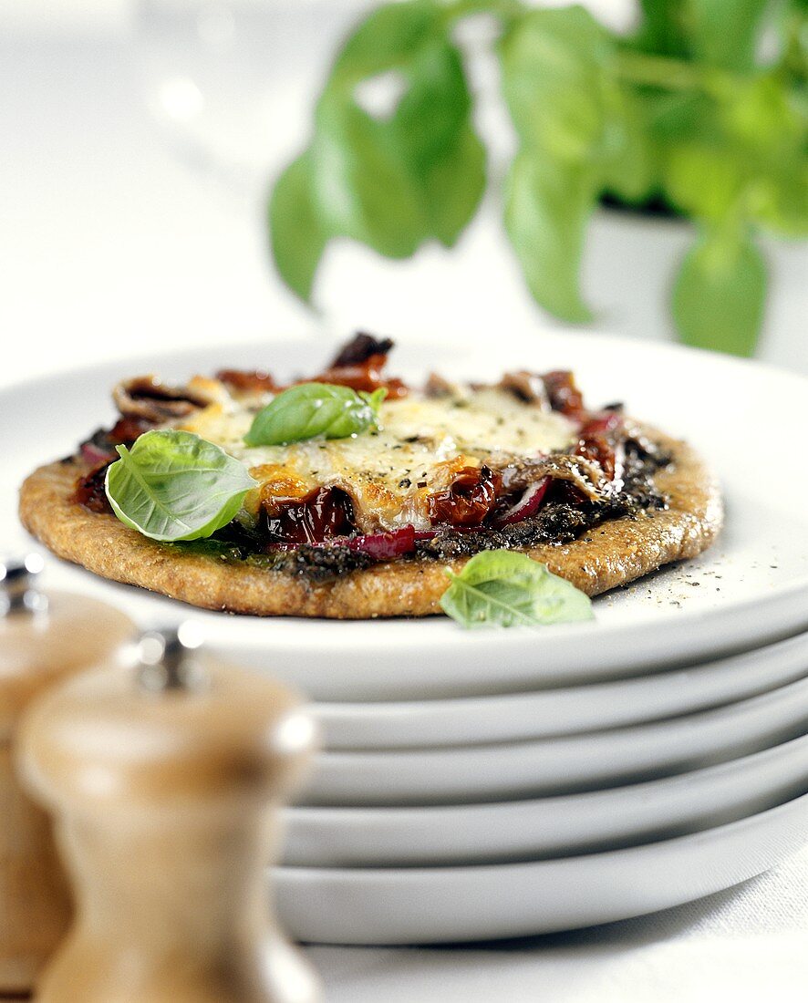 Pizza mit Tomaten, Anchovis, Käse und Basilikum