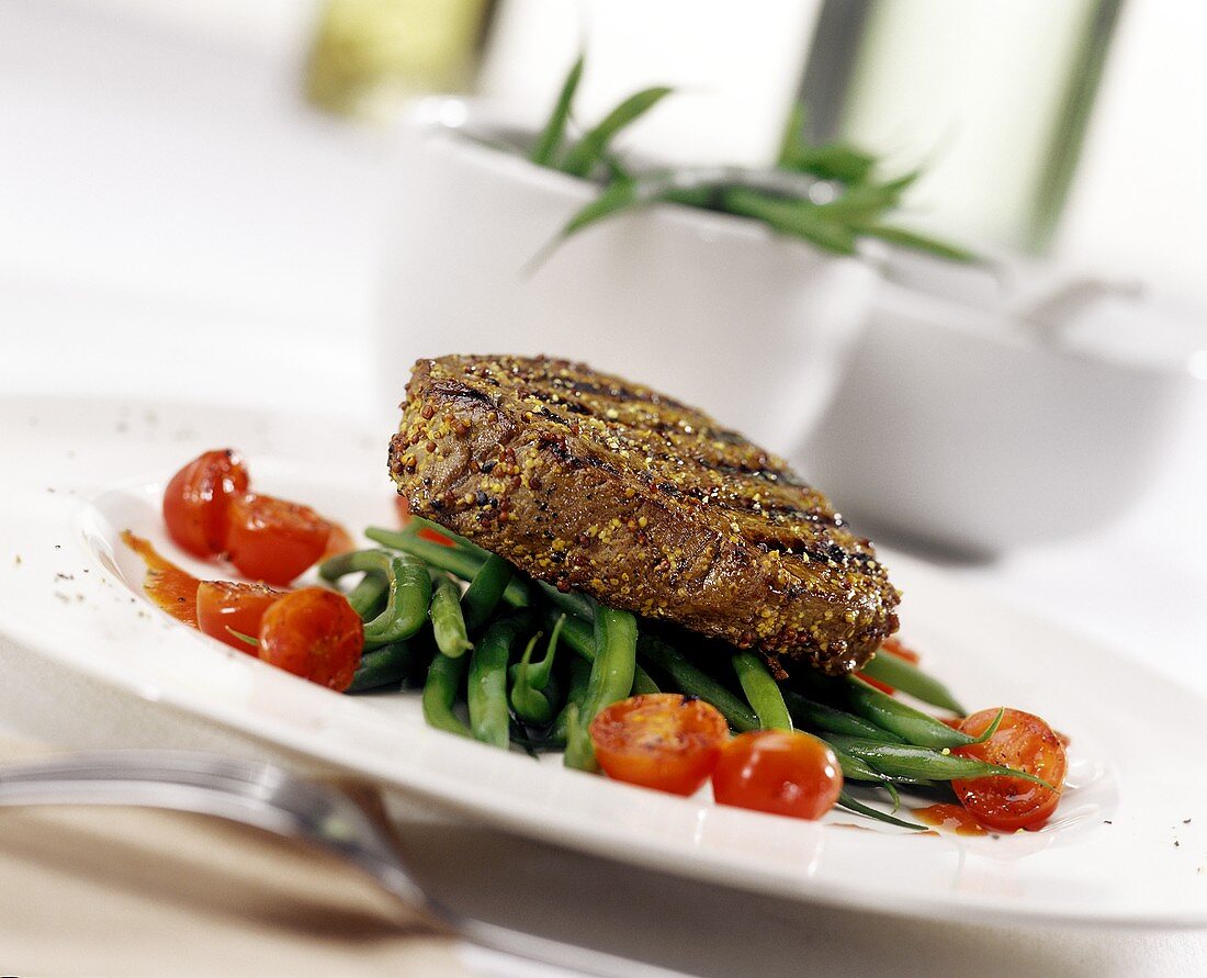 Peppered steak on green beans with cherry tomatoes