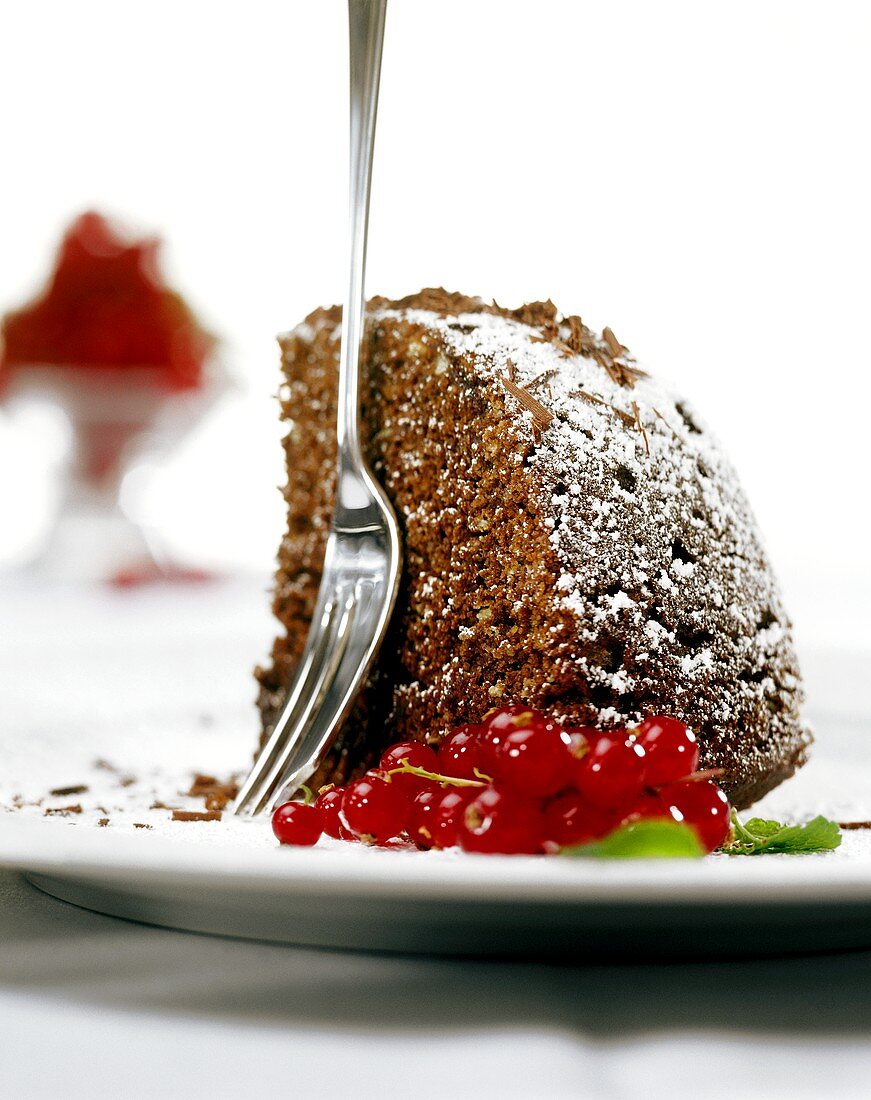 Stück Schoko-Nuss-Kuchen mit Puderzucker; Johannisbeeren