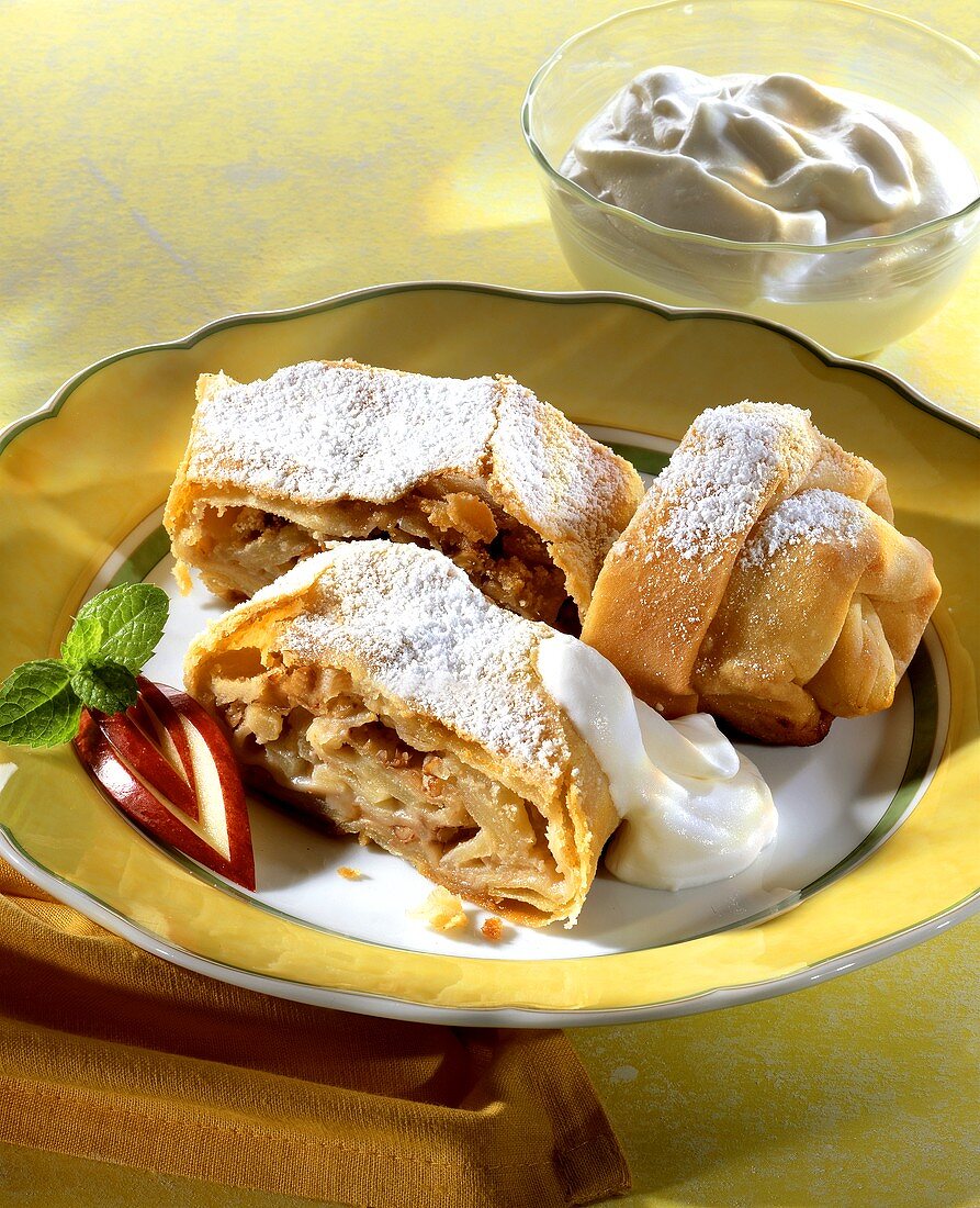 Apple and walnut strudel with cream and icing sugar
